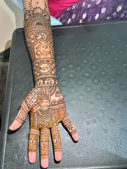 A single arm shot of the groom portrait mehendi, showcasing the intricate patterns that surround the central figure.