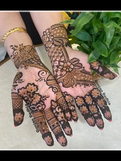 A designer mehendi piece with a mix of floral and paisley patterns. The intricate details and shading make this a truly special design.