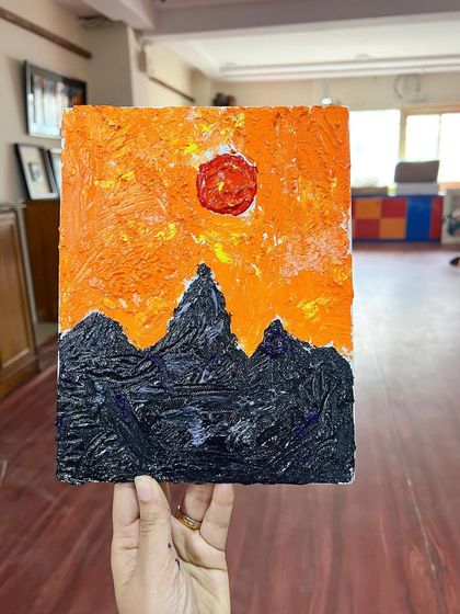 A fiery sunset over dark mountains, captured with bold textures using a palette knife. This piece was created by a young student in one of our classes.