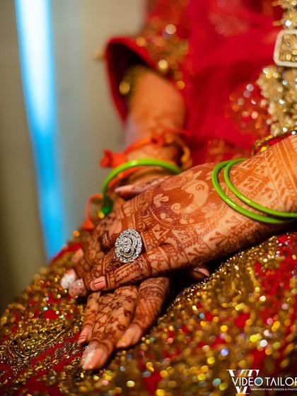 A close up of a bride's hands, showing the beautiful dark stain of her mehndi against her ornate wedding dress. It’s the perfect finishing touch.