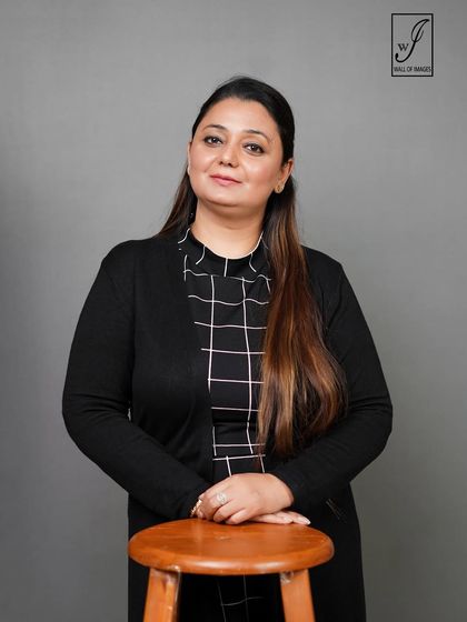 A corporate portrait with the subject leaning on a stool, creating a friendly and approachable vibe.