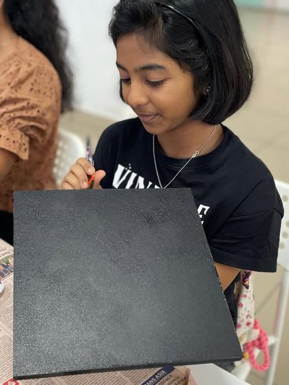 A blank canvas ready for creativity. This participant is painting her board black before starting her string art project.