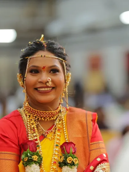 A happy bride during her Vidhi ceremony. The yellow and red saree combination is vibrant, and her makeup is fresh and glowing.