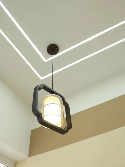 A close-up of a pendant light being installed as part of the false ceiling design.