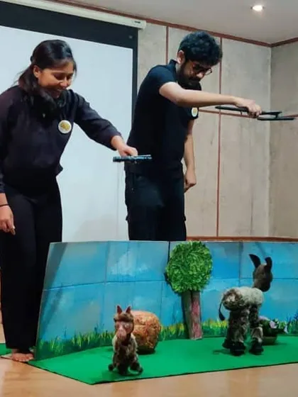A performance in progress. You can see the puppeteers working together to control the characters on the mini stage.