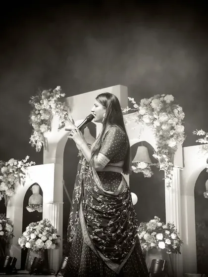 A dramatic black and white shot of me on stage, with beautiful floral arrangements and lighting creating a magical, dreamy atmosphere.