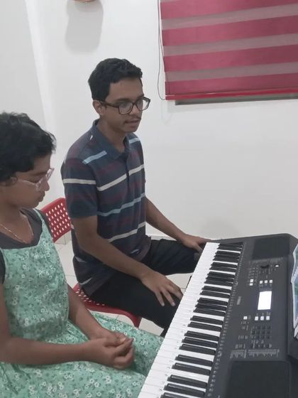 Another angle of a keyboard lesson, showing the close interaction between the student and teacher.