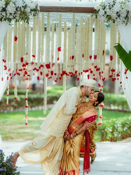 A quiet, stolen moment of affection amidst the beautiful rituals of a South Indian wedding. I focus on capturing the deep connection between the couple, framed by the traditional decor like these delicate floral hangings.