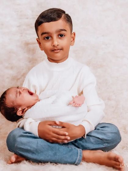 Even when the little one is a bit fussy, the big brother's patience and care shine through. I photograph the real moments, not just the perfect smiles.