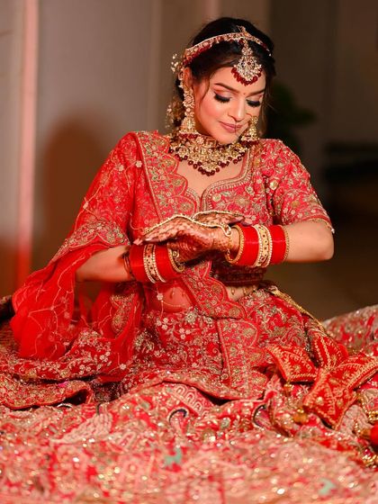 Another angle of the seated bride, capturing the rich details of her red and gold bridal wear.