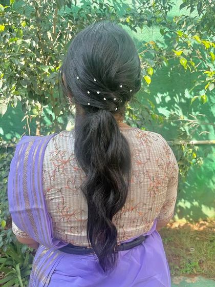 A simple ponytail with scattered pearl pins, an elegant and understated look.