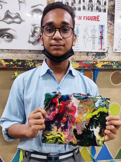 Even our younger students get to explore modern techniques. Here's a student with his vibrant and colorful first piece of fluid art.