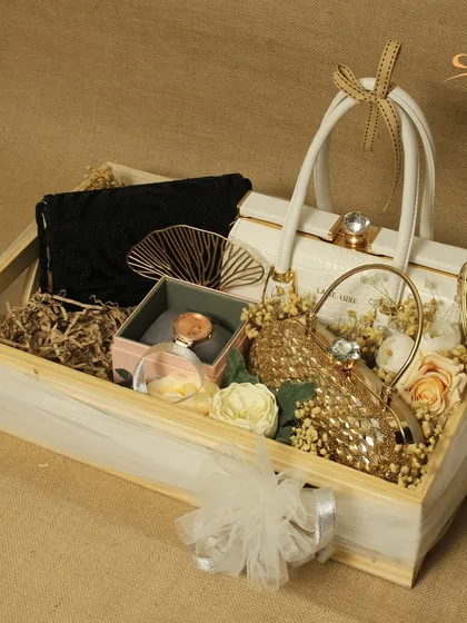 This elegant hamper in a white wooden tray is curated with luxury accessories, including a handbag, a watch, and a clutch, making it a perfect gift for a bride-to-be or for a special birthday.