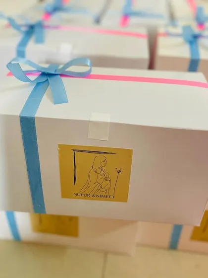 Another look at our baby shower favor boxes, showing the pink and blue ribbon detail. We love helping our clients celebrate life's biggest moments.