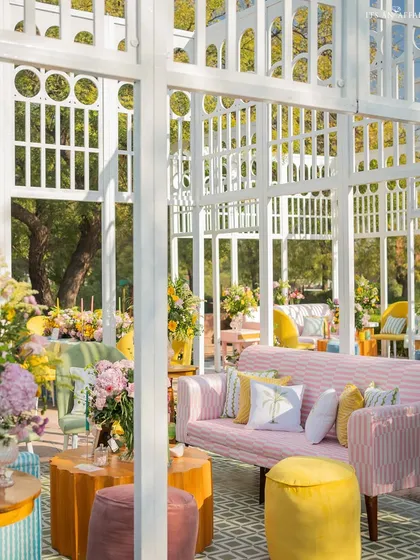 An interior view of a trellis lounge, showing the mix of colorful furniture, patterned flooring, and abundant floral arrangements.