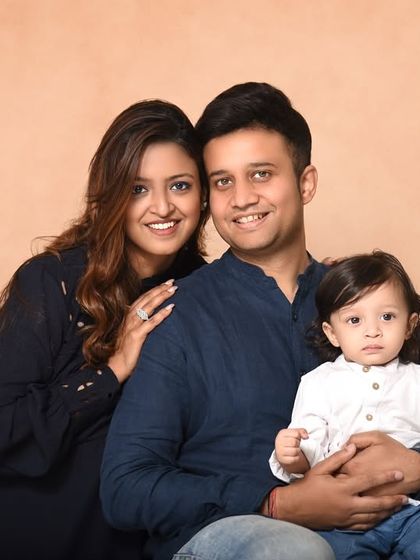 A classic family portrait against a warm, painted canvas backdrop. This formal yet relaxed pose is perfect for creating a timeless piece of art for your home.