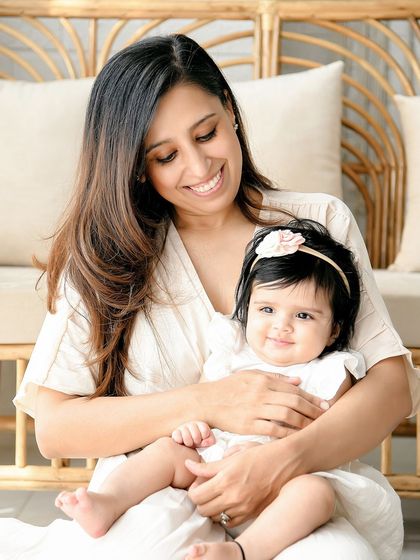 A lovely close-up of a mother and her baby girl. The mother's smiling gaze down at her child captures a moment of pure maternal love.