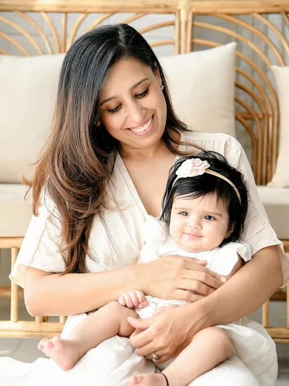 A lovely close-up of a mother and her baby girl. The mother's smiling gaze down at her child captures a moment of pure maternal love.
