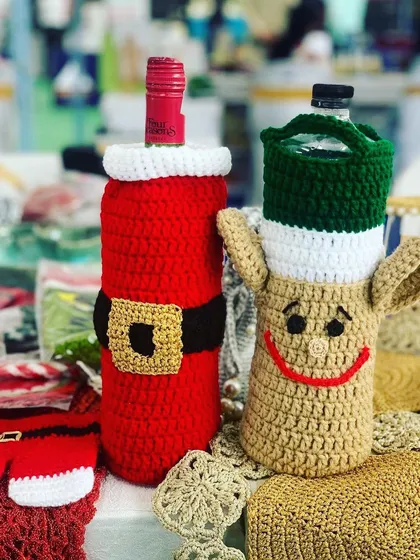 A Santa and reindeer bottle cover, perfect for gifting wine during the Christmas season.