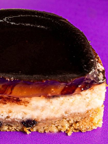 A macro shot of the Bebe Frank, showing the layers of cookie base, baked cheesecake, caramel, and that signature boozy ganache.