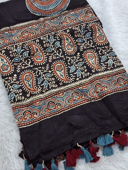 This Ajrakh modal fabric with a paisley border and tassels is perfect as a dupatta or for tailoring. The rich colors and soft texture make it a luxurious choice.