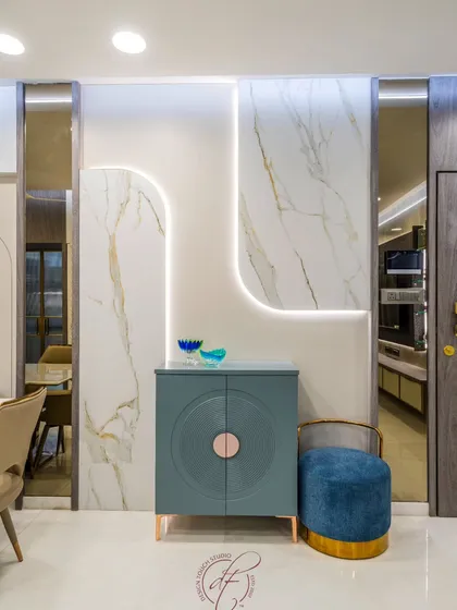 A close-up of the custom console area, featuring a beautiful blue cabinet with a unique circular handle. The backlit marble wall panel adds a touch of drama and sophistication to this functional corner.