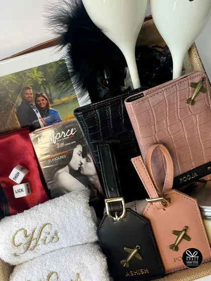 A sweet and spicy hamper for a couple, featuring personalized 'His & Hers' passport covers and luggage tags, matching towels, and some fun, naughty games.