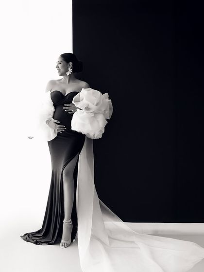 A full-length portrait showcasing the dramatic silhouette of this stunning black and white gown. The long train adds so much elegance.