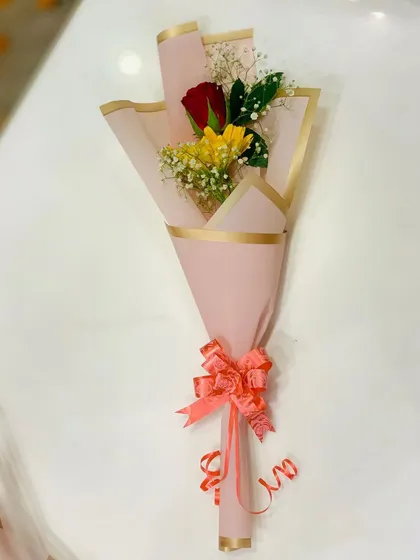 A sweet mini-bouquet with one red rose and one yellow gerbera daisy. The simple pink wrapping makes it a lovely, small token of appreciation.