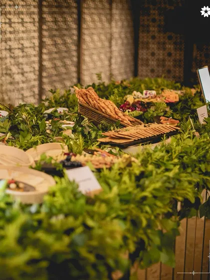 A sprawling grazing table covered in a bed of fresh parsley and greens. This unique "meadow" concept creates a stunning visual and highlights the freshness of the ingredients.