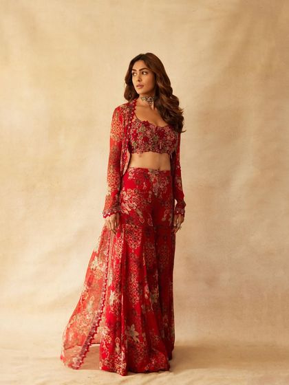 For a promotional shoot, Mrunal embodied Rabia's essence in this stunning red floral ensemble by Ridhima Bhasin. The look consists of a detailed bustier, matching trousers, and a flowing cape, paired with a custom choker to create a powerful, cohesive statement.