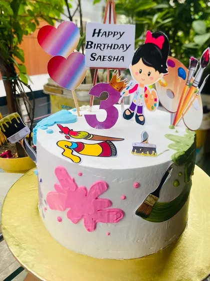 A colorful art-themed cake for a creative 3-year-old's birthday.