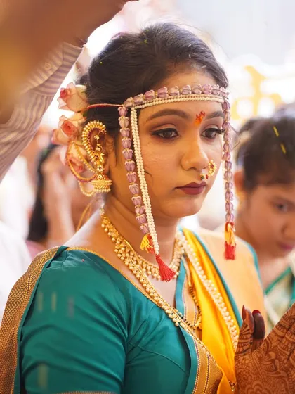 The bride during a solemn ritual. The makeup is applied to look respectful and elegant, with a focus on defined eyes and a matte finish.