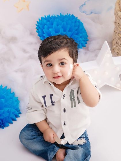 A simple and sweet portrait of a little boy in a blue-themed setup, showing off his curious and gentle personality.