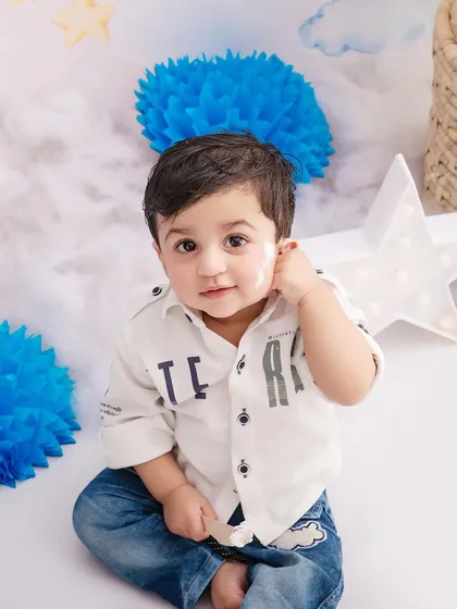 A simple and sweet portrait of a little boy in a blue-themed setup, showing off his curious and gentle personality.
