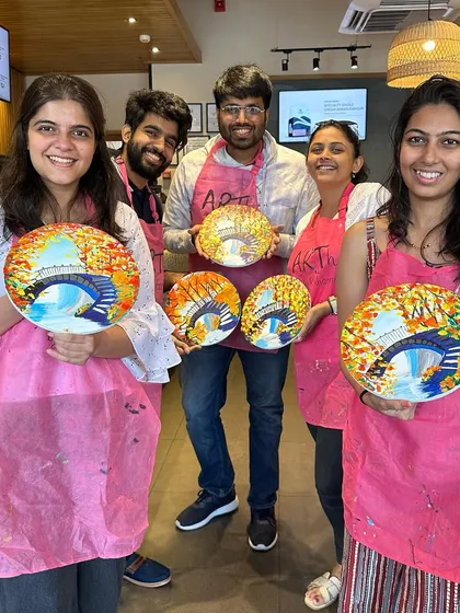 A group of friends proudly displaying the beautiful bridge landscapes they painted on plates. I offer workshops on various surfaces, not just canvas.