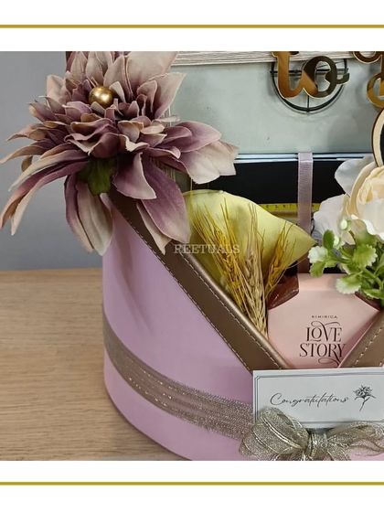 A side view of the elegant pink hat box hamper, showcasing the beautiful floral arrangement and the "Congratulations" gift tag.