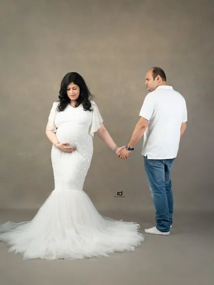 Holding hands, ready to walk into the future together. This full-length shot showcases the beautiful mermaid-style gown and the simple, strong connection between the couple.