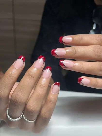 A classic French manicure, but make it bold. These red glitter French tips are for when you want to feel powerful and a little bit dangerous. This is a structured gel overlay on natural nails.