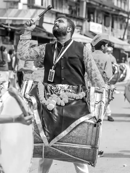 A black and white version of the dhol player in a moment of musical ecstasy.