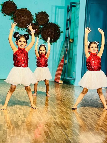 Three of our beginner students striking a powerful pose. We teach them to perform with confidence and joy from their very first day.
