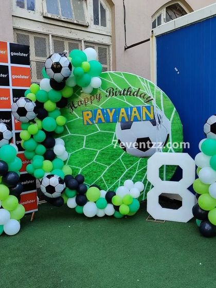 A football-themed birthday decoration for an 8-year-old, featuring a goal-net backdrop, football-print balloons, and a large "8" cutout.