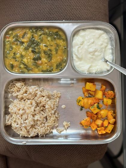 A simple and light meal of brown rice with dal palak, sautéed pumpkin, and a side of curd.