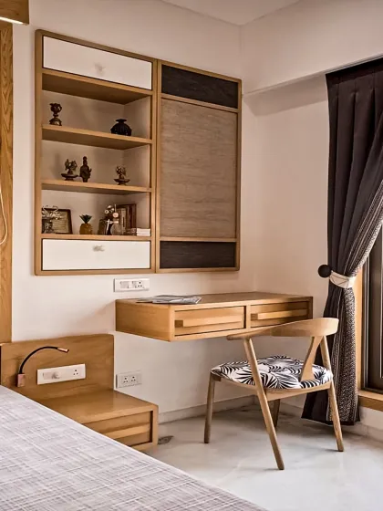 A compact and efficient study corner within a bedroom. The design includes a floating desk and wall-mounted shelving, making use of vertical space to create a functional work area without a large footprint.