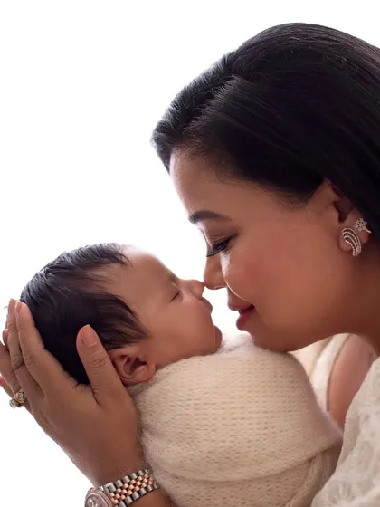 Comedian Bharti Singh holds her newborn son Laksh, their noses touching in a tender moment. A beautiful example of a mother and son photoshoot.