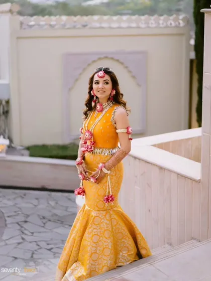 A full view of the custom marigold mermaid skirt and hand-embroidered blouse. This outfit combines a traditional Banarasi fabric with a modern fish-cut silhouette, perfect for a bride who wants a unique Haldi look.