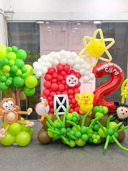 I love bringing entire worlds to life, like this farm-themed sculpture for a second birthday. It features a whole cast of characters including a cheeky monkey, a happy sun, and a red barn, all meticulously crafted from balloons to create an immersive party scene.