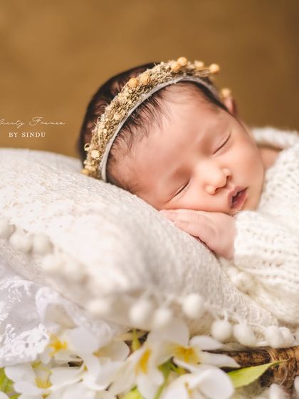 A close-up of pure innocence. This newborn, with a delicate floral crown, is sleeping so soundly. These are the moments you’ll want to remember forever.