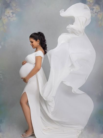 The magic of a fabric toss. This dynamic shot adds movement and a "wow" factor to a classic maternity portrait.