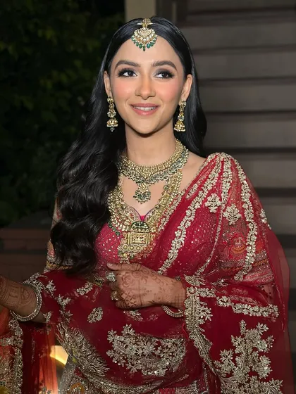 A beautiful candid moment of my bride. Her soft, smoky eye makeup and peachy nude lips create a look of subtle sophistication that perfectly complements her traditional red wedding attire.